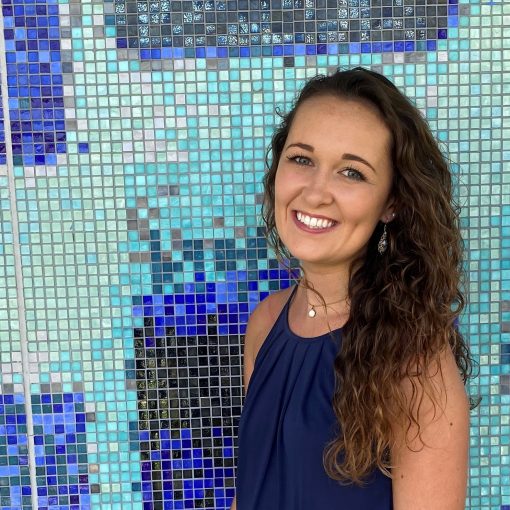 Emily Green, ITEHP trainee, in front of a blue tiled background.