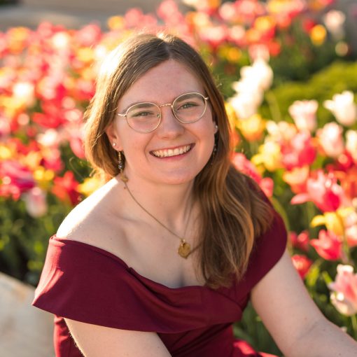 Rebecca Hoehn, smiling in front of a garden of tulips