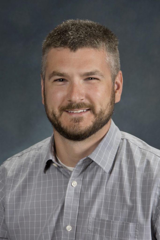 Headshot of Dr. Andrew Wojtovich, wearing a light gray button up shirt